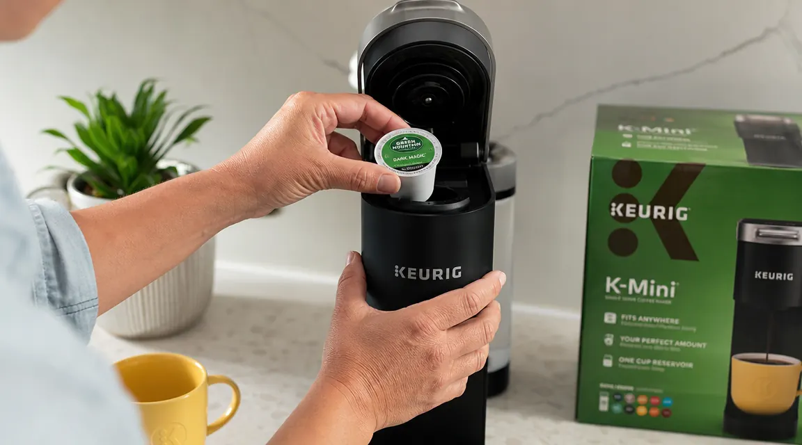 Hand placing a K-Cup pod into the Keurig K-Mini brew chamber